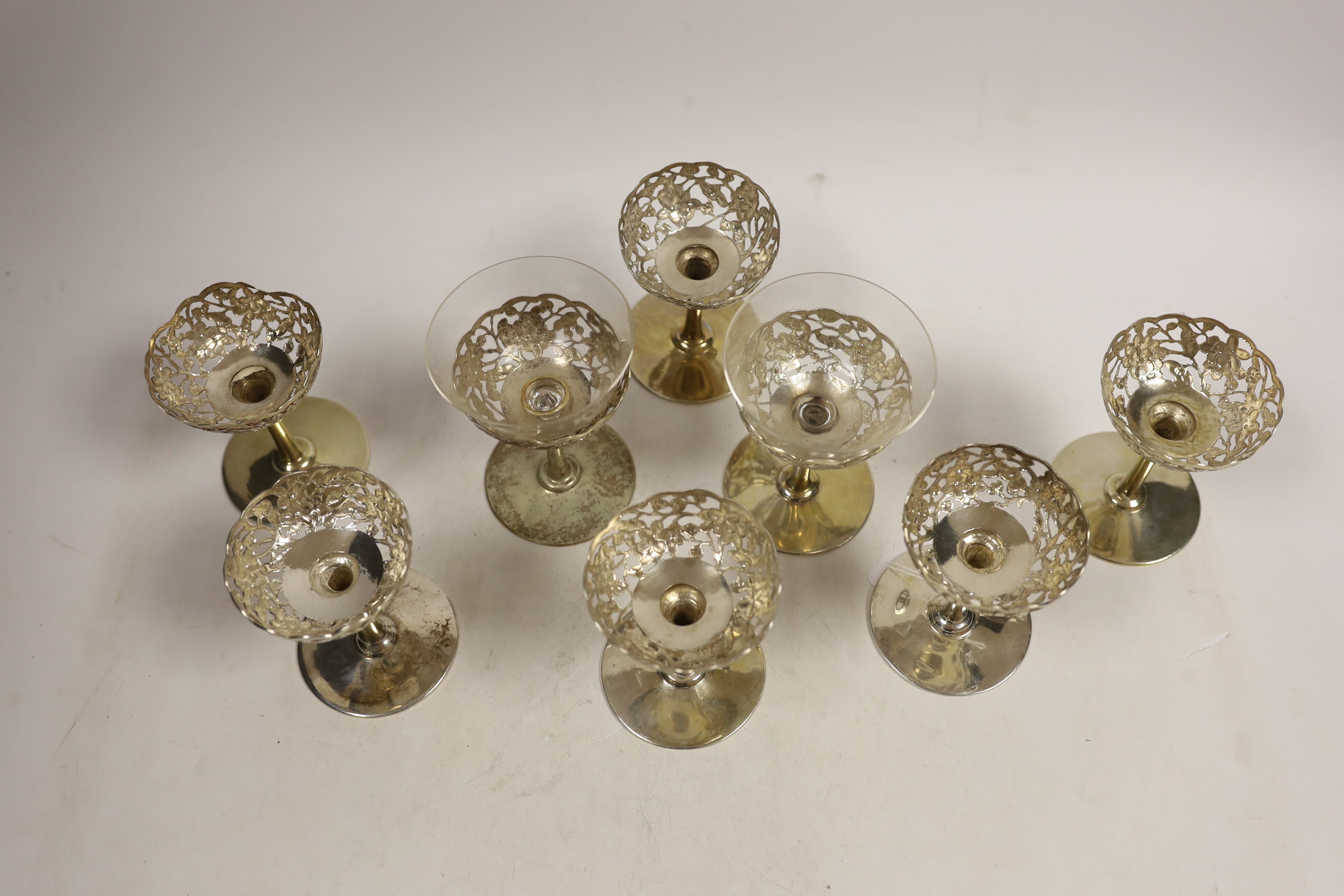 A matched set of eight pierced white metal coupes, two with glass inserts, six stamped with Chinese character mark, two stamped 'silver', height 87mm.